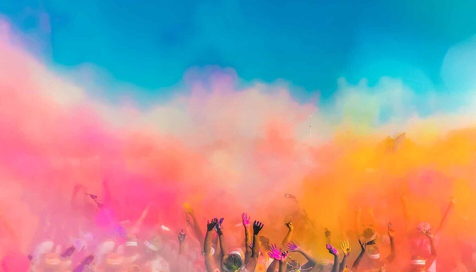 Bunte Farben und Hände im Himmel beim Holi Festival