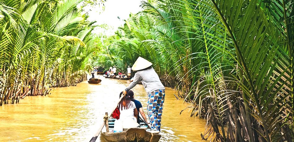 Reisende auf einem Ruderboot im Mekong Delta