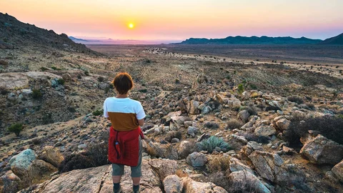 Reisende bei Sonnenuntergang in der Namib Wüste