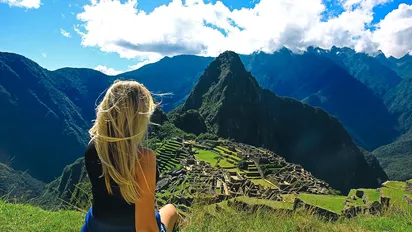 Eine Frau, die auf den Machu Picchu hinunter blickt, Peru 