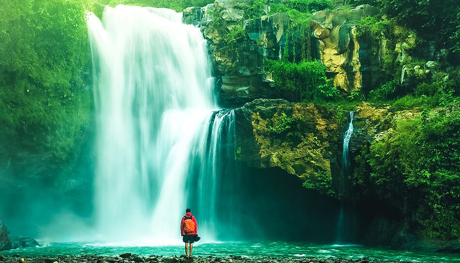 Reisender vor einem Wasserfall in Costa Rica