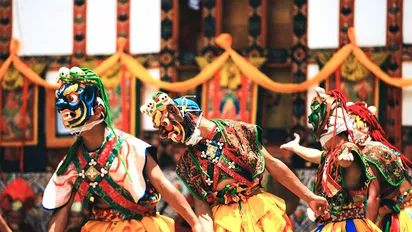 Tänzer in Bhutan in traditioneller, bunter Kleidung