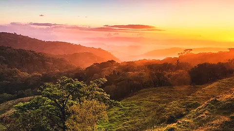 Sonnenuntergang in der Hügellandschaft bei Monteverde, Costa Rica