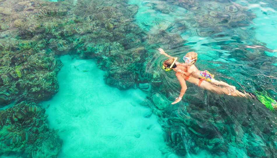 Mutter und Kind beim Schnorcheln im Korallengebiet