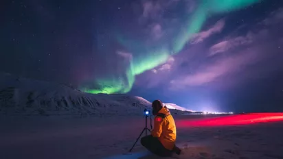 Fotograf vor Polarlichtern in Spitzbergen