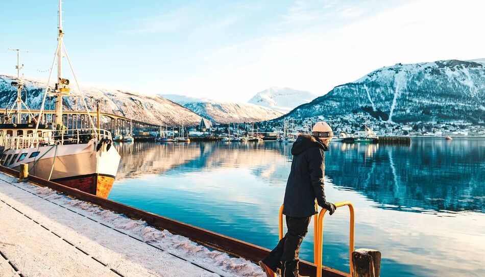Ein Teenager genießt den Ausblick auf Tromsø im Winter