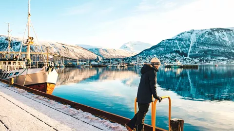 Ein Teenager genießt den Ausblick auf Tromsø im Winter