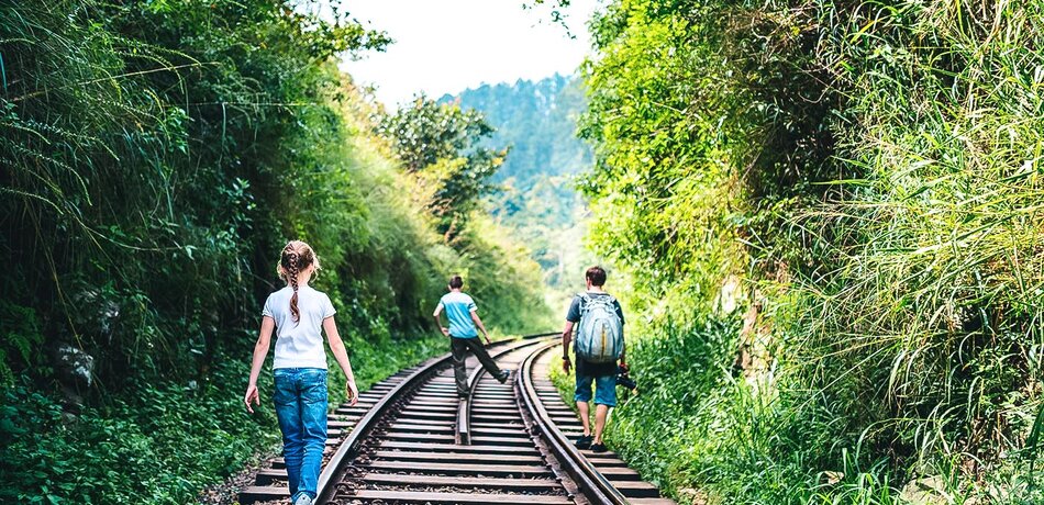 Eine Familie, die über eine Zugstrecke in Sri Lanka läuft
