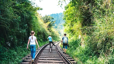 Eine Familie, die über eine Zugstrecke in Sri Lanka läuft