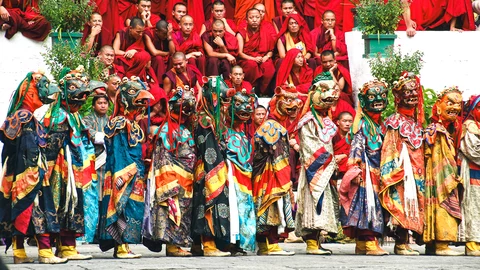 Traditionelle Tänzer in ihren Kostümen und Mönche auf dem Lhuntse Tshechu Festival