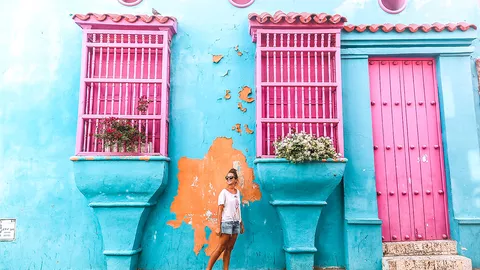 Frau vor einem bunten Haus in Cartagena
