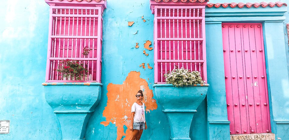 Frau vor einem bunten Haus in Cartagena
