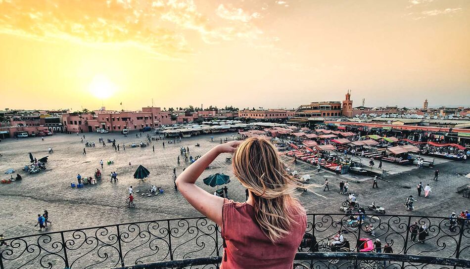 Frau blickt auf Marktplatz in Marrakech, Marokko