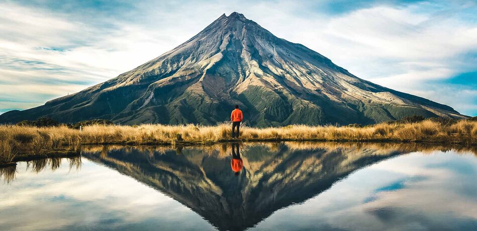 Ein Wanderer vor dem Taranaki Vulkan