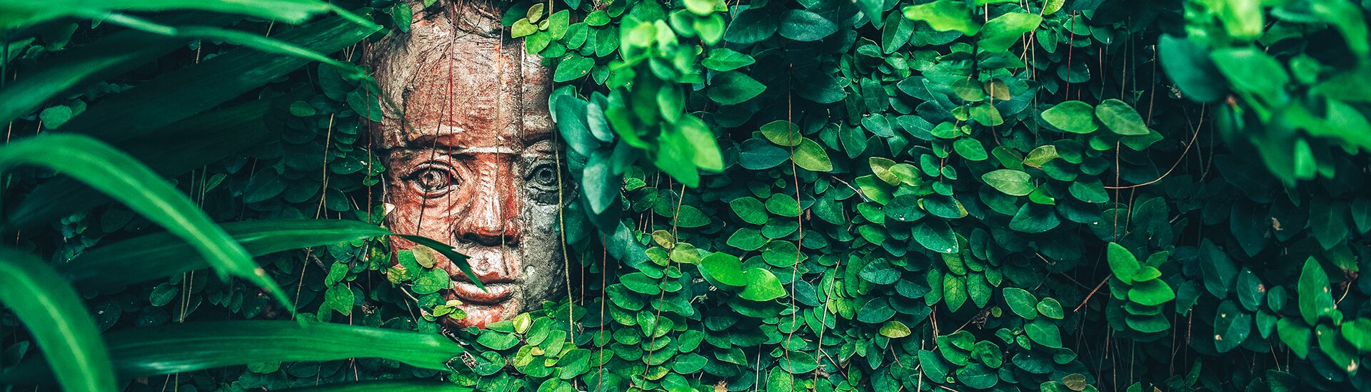 Maya Statur umgeben von Blättern 