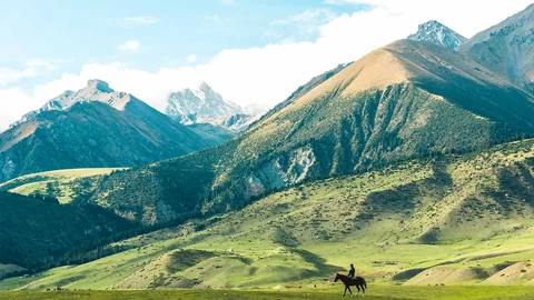 Reiter auf grüner Wiese im Jyrgalan Tal 