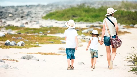 Eine Familie spaziert den Strand der Insel North Seymour entlang, Galapagosinseln, Ecuador