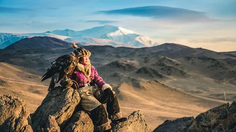 Mädchen mit Adler auf dem Arm in der Mongolei