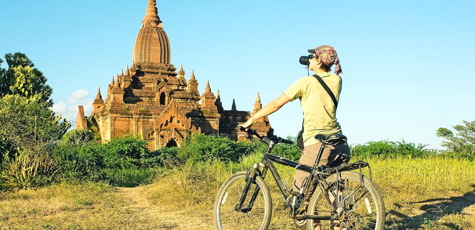 Frau auf Fahrrad vor Bagan, Myanmar