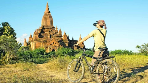 Frau auf Fahrrad vor Bagan, Myanmar
