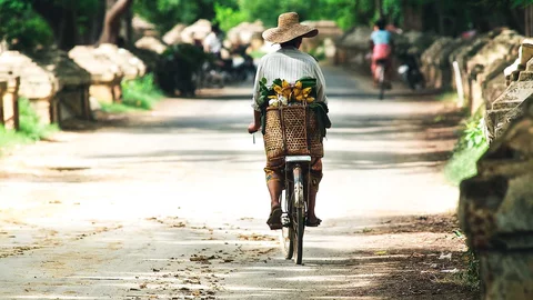 Frau auf Fahrrad in Mandalay, Myanmar